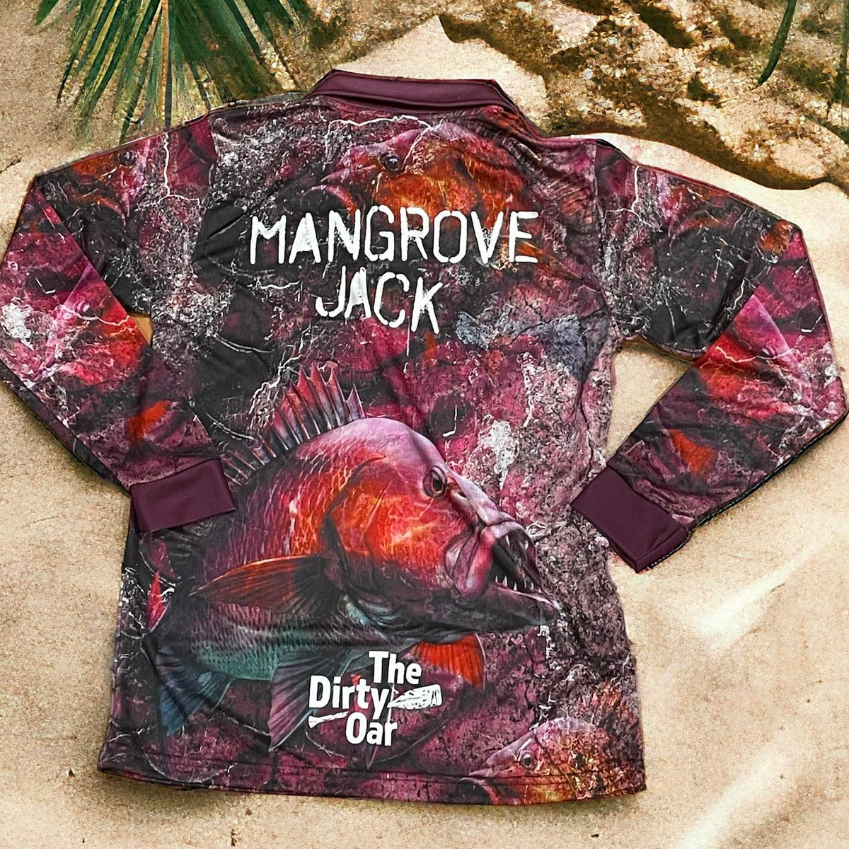 The Dirty Oar Mangrove Jack Mens Fishing Shirt on sandy background with plams.