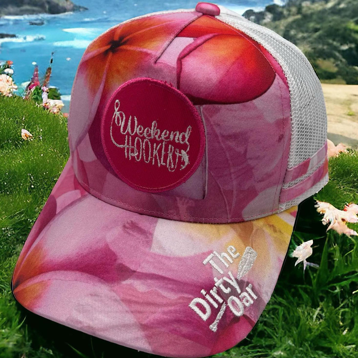Frangipani Ponytail Trucker Cap, set against a coastal backdrop.