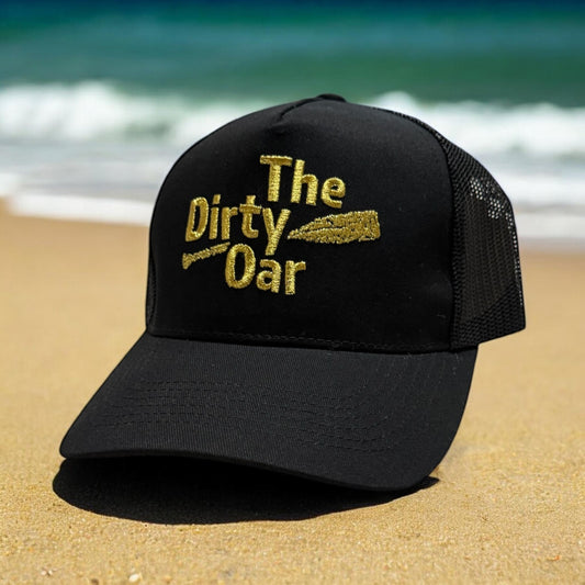 Dirty Oar Gold Trucker Cap on a beach
