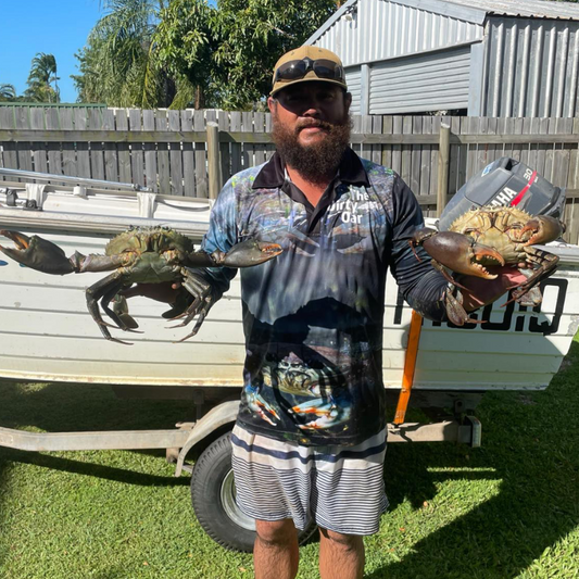 Man holding 2 big bucks wearing The Dirty Oar Mud Crab Mens Fishing Shirt in front of tinny.