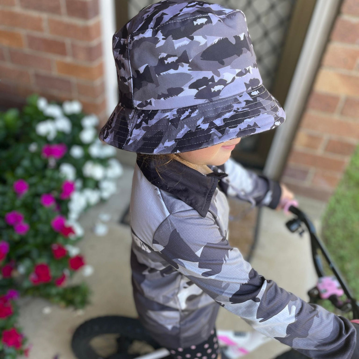 The Dirty Oar Coral Trout Kids Bucket Hat on Childs head with Coral Trout Kids Fishing Shirt.
