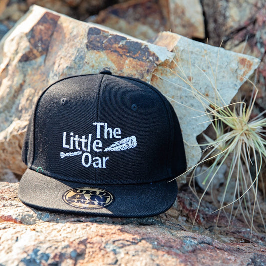 The Little Oar Flat Brim Cap on rocks 